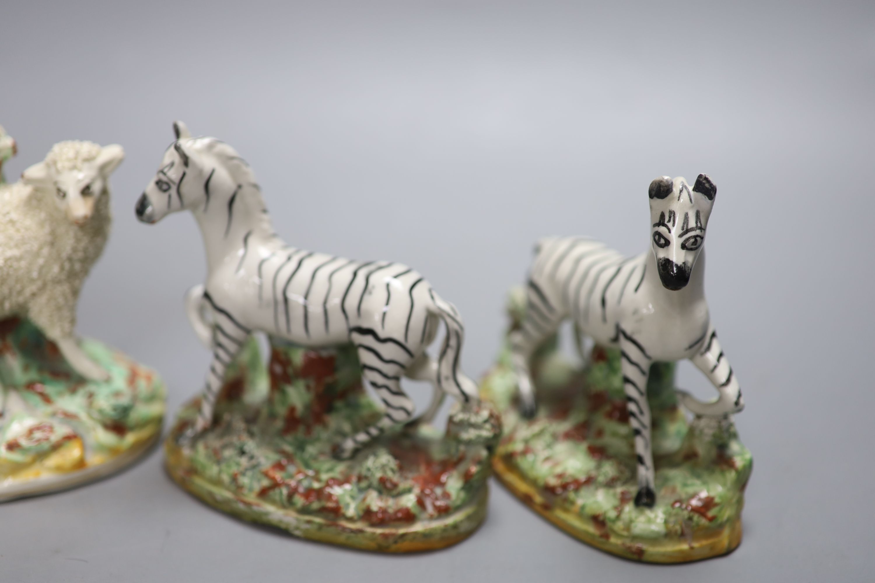 A pair of Staffordshire flatback Zebra and a pair of sheep spill vases